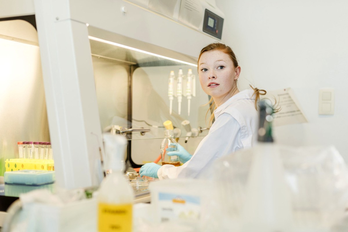 A person working carefully in a bright, modern workspace.