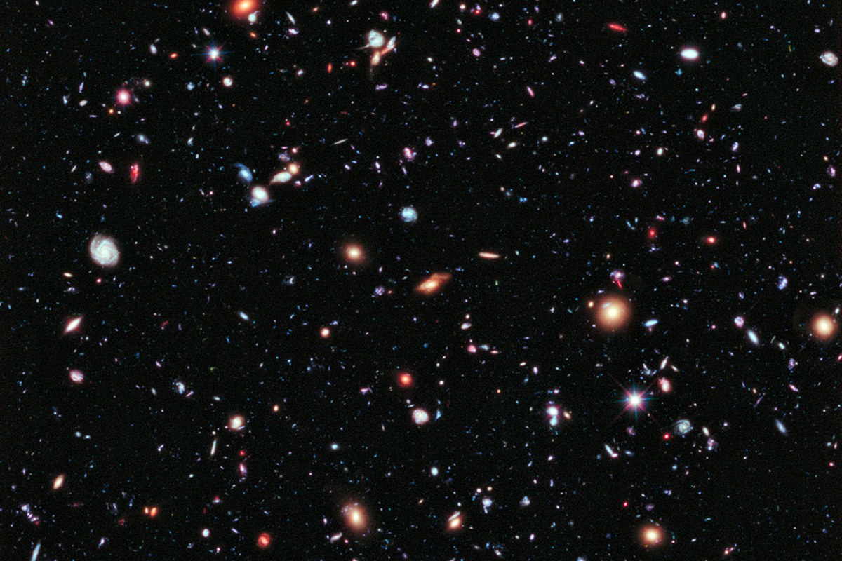 A dense field of distant stars and galaxies against dark space.